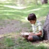 森の中で本を読む少年